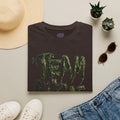 Dark brown protest tee with dripping green 'TEAM' text, styled with hat, jeans, and succulents.
