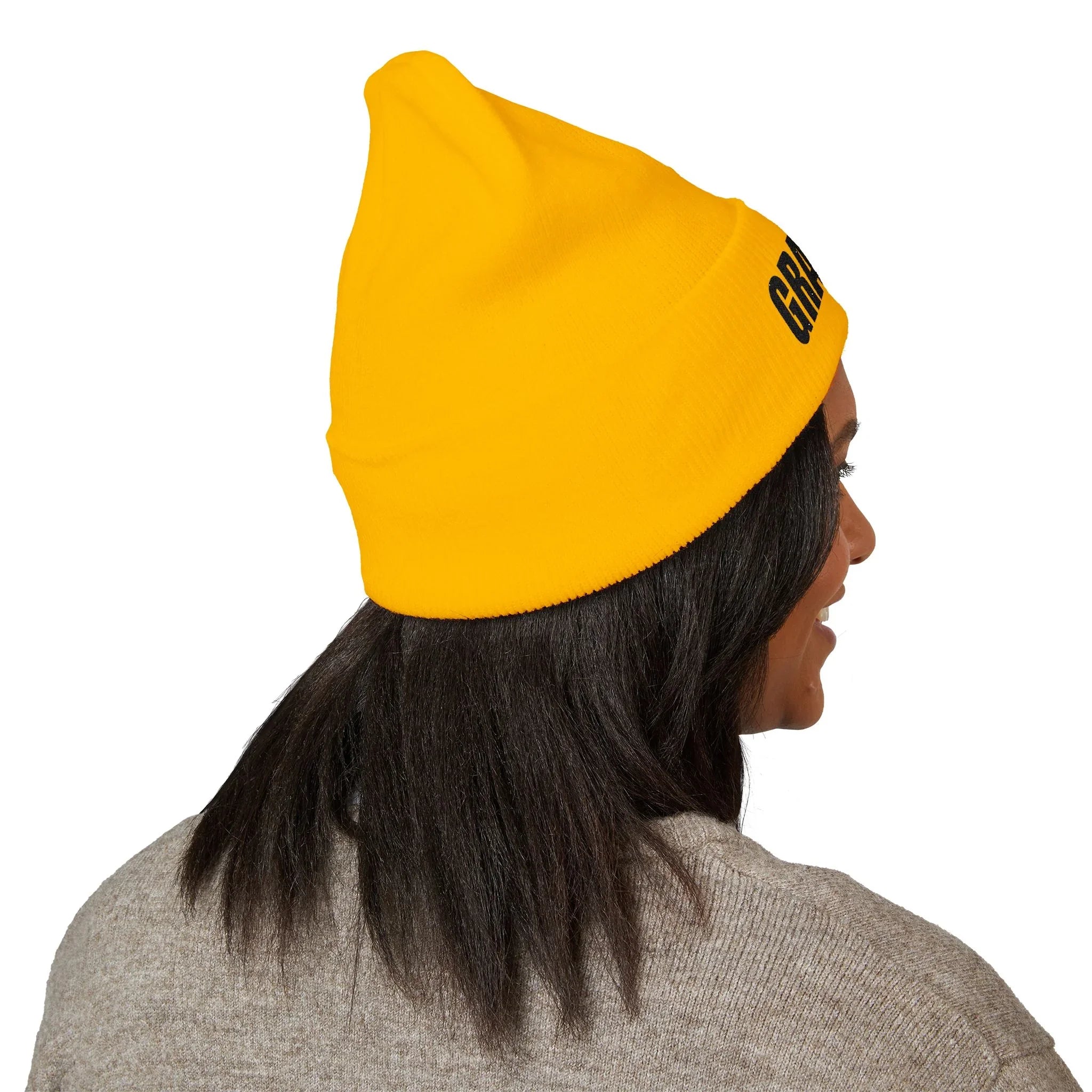 Person wearing a bright yellow beanie with black protest text, activism apparel