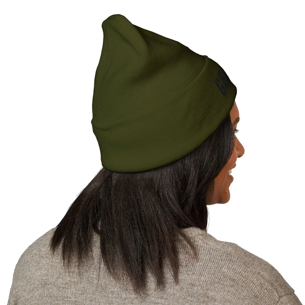 Woman in an olive green protest beanie, activism-inspired statement hat, side view
