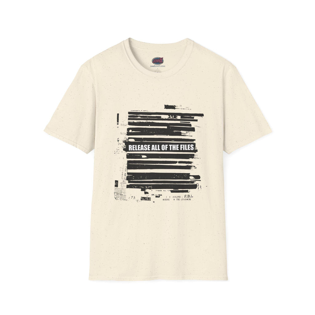 May include: Cream-colored t-shirt with a crew neck. The front features a black graphic resembling redacted documents, with the text "RELEASE ALL OF THE FILES" in white. The shirt has a speckled texture.