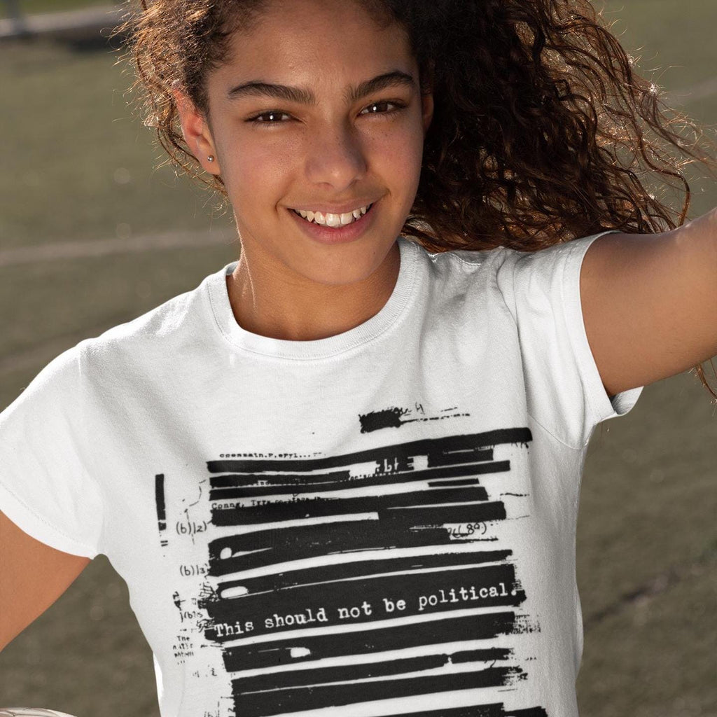 May include: White t-shirt with a black graphic design. The design features horizontal black bars and the text "This should not be political." A small logo is visible on the neckline.
