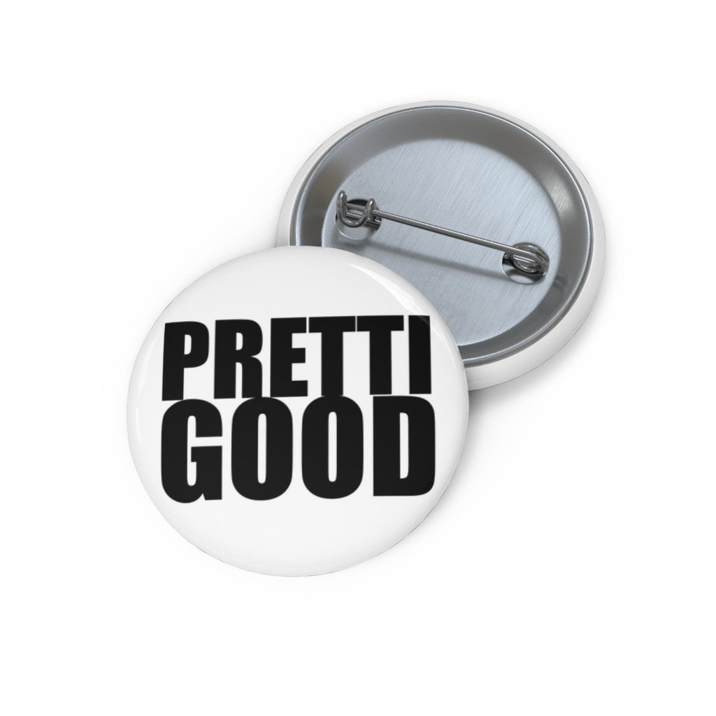 May include: Two white round buttons with metal pin backs. One button has the words "PRETTI GOOD" in bold black letters. The other button is visible in the background.